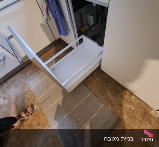 מגירת מטבח לבנה יצאה ממקומה בארון במהלך תיקון או פירוק
